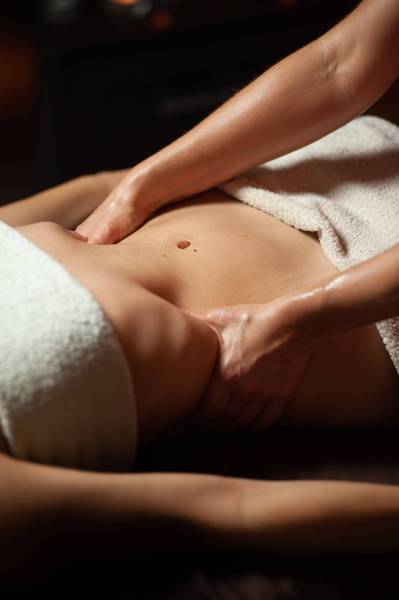 Beautiful young woman having visceral massage in spa center